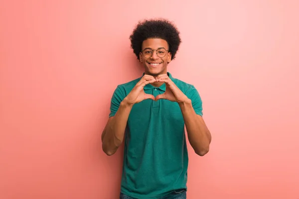 Νεαρός Αφροαμερικάνος Πάνω Από Ένα Ροζ Τοίχο Κάνοντας Σχήμα Καρδιάς — Φωτογραφία Αρχείου