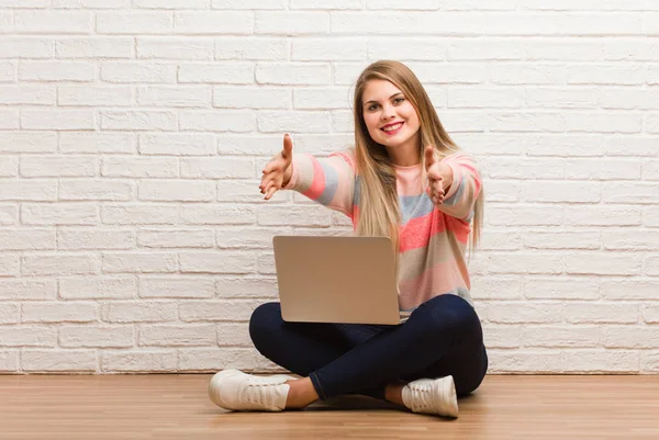 Genç Rus öğrenci çok mutlu bir şekilde oturuyor ve ön tarafa sarılıyor.