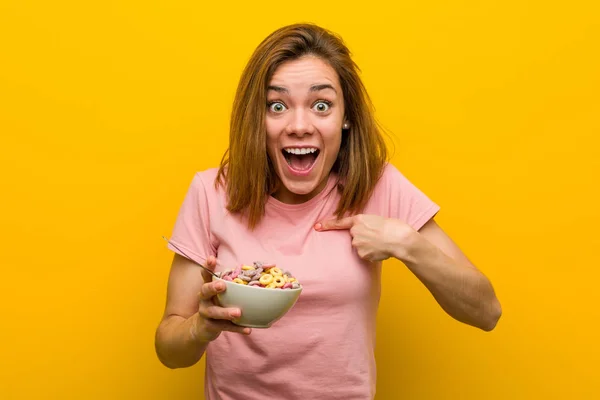 Mujer Joven Sosteniendo Tazón Cereales Sorprendida Señalándose Misma Sonriendo Ampliamente —  Fotos de Stock