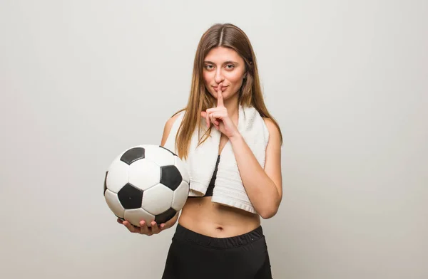 若いフィットネスロシアの女性は秘密を保持するか 沈黙を求めています サッカーボールの保持 — ストック写真
