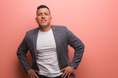 Kalçasında elleri olan genç, zarif Latin bir adam.