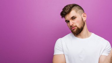 Genç, yakışıklı, beyaz bir adam başının arkasına dokunuyor, düşünüyor ve bir seçim yapıyor..