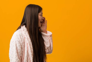 Pijama giymiş genç Çinli bir kadın bağırıyor ve avuç içini açıyor..