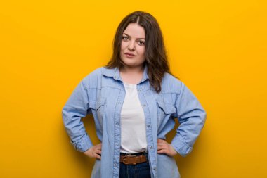 Young curvy plus size woman confident keeping hands on him hips.