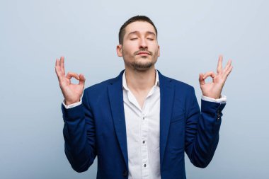 Genç iş adamı Kafkasyalı yorucu bir günün ardından rahatlıyor. Yoga yapıyor..