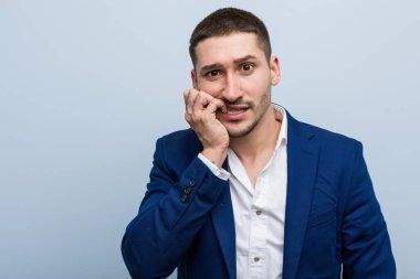 Tırnak yiyen genç beyaz bir adam. Gergin ve endişeli..