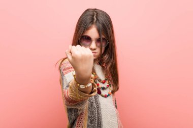 Küçük hippi kız kameraya yumruk gösteren, agresif yüz ifadesi.