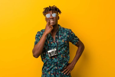 Tatil giymiş genç siyah Rasta adam rahatlamış görünüyor. Bir şeyin fotokopi odasına baktığını düşünüyor..