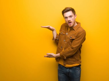 Genç kızıl saçlı adam çok şaşırmış ve şok bir şey tutan