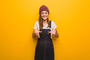 Genç hippi kadın parmaklarıyla dibi gösteriyor.