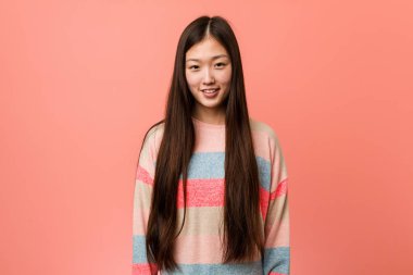 Genç havalı Çinli kadın mutlu, güler yüzlü ve neşeli.