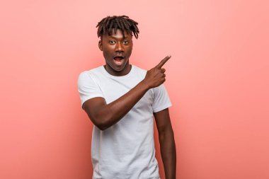 Genç Afrikalı siyahi adam yan tarafı gösteriyor.