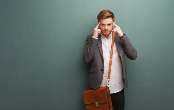 Young redhead business man doing a concentration gesture