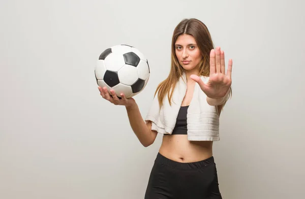 若いフィットネスロシアの女性が手を前に置く サッカーボールの保持 — ストック写真