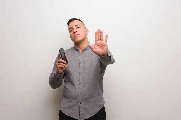 Junger Lateinischer Mann Der Ein Telefon Hält Und Die Hand — Stockfoto