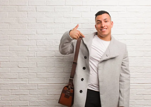 Genç Latin iş adamı, gömleğin fotokopi odasını elle gösteriyor, gururlu ve kendinden emin.