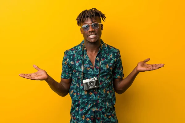 Young black rasta man wearing a vacation look showing a welcome expression.