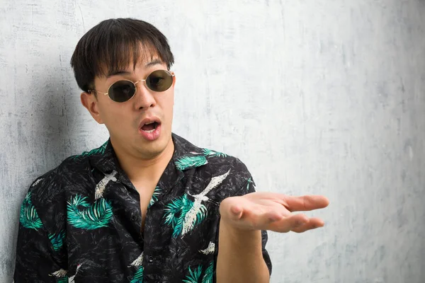 Young Chinese Man Wearing Summer Outfit Holding Something Very Surprised — Stock Photo, Image