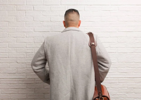 Young latin business man from behind, looking back