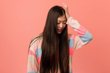 Genç, havalı Çinli kadın bir şey unutuyor. Alnına avuç içiyle vurup gözlerini kapatıyor..