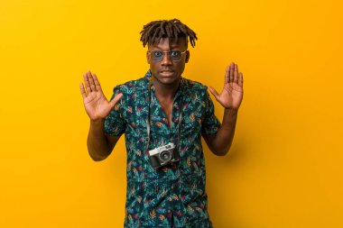 Tatil kıyafeti giyen genç siyah Rasta, tiksinti ifadesi sergileyen birini reddediyor..