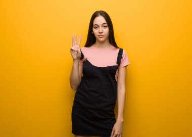 Genç doğal güzel kız üç numarayı gösteriyor.