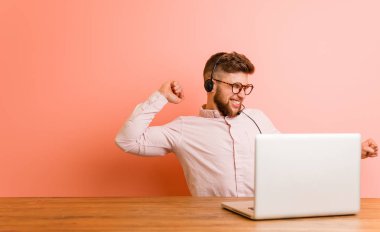 Çağrı merkezinde çalışan genç adam dans ediyor ve eğleniyor..