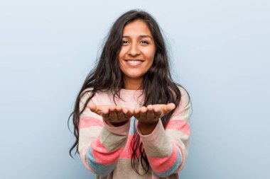 Genç moda Hintli kadın avuçlarıyla bir şey tutuyor, kameraya sunuyor..