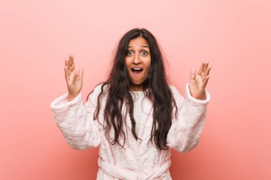 Pijama giyen genç Hintli kadın hoş bir sürpriz alıyor, heyecanlı ve el kaldırıyor..