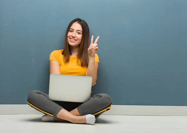 Молодая Женщина Сидящая Полу Ноутбуком Показывающим Номер Два — стоковое фото