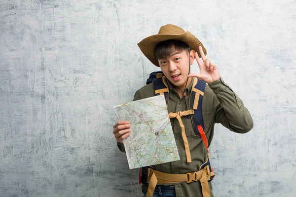 若いです中国の探検家男保持Aマップ楽しいと幸せ行うAジェスチャーの勝利 — ストック写真