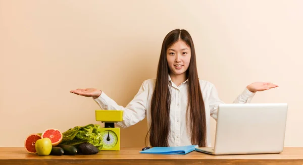 Jovem Nutricionista Mulher Chinesa Trabalhando Com Seu Laptop Mostrando Uma — Fotografia de Stock