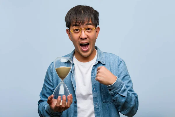 Jovem Chinês Segurando Temporizador Areia Surpreso Sente Bem Sucedido Próspero — Fotografia de Stock