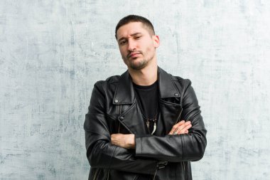 Genç rockçı mutsuz, iğneleyici ifadesiyle kameraya bakıyor..