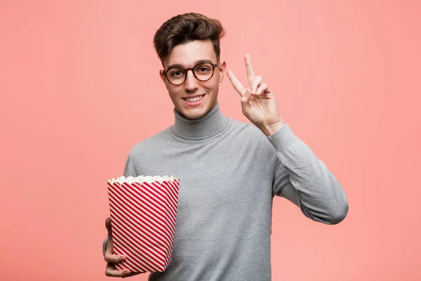 Young Intellectual Man Holding Popcorn Bucket Looking Sideways Doubtful Skeptical — Stock Photo, Image