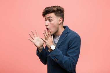 Genç iş adamı bağırır, gözleri açık ve elleri gergin tutar..