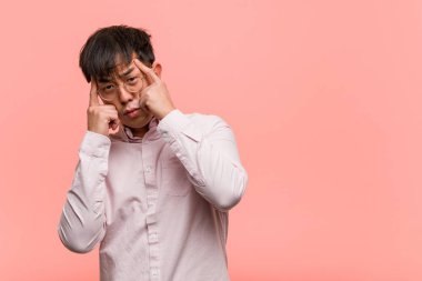 Young chinese man doing a concentration gesture