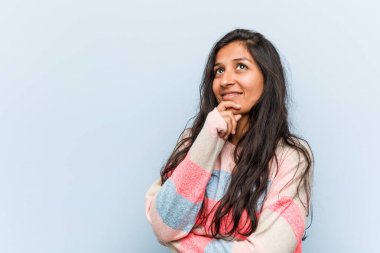 Genç moda Hintli kadın şüpheli ve şüpheci bir ifadeyle yana bakıyor..