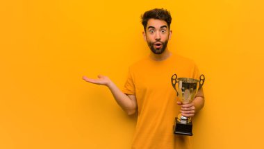 Elinde bir kupa tutan genç bir adam.