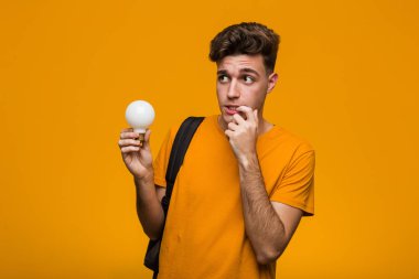 Elinde ampul tutan genç bir öğrenci tasasız ve heyecanlı tezahürat yapıyor. Zafer konsepti.