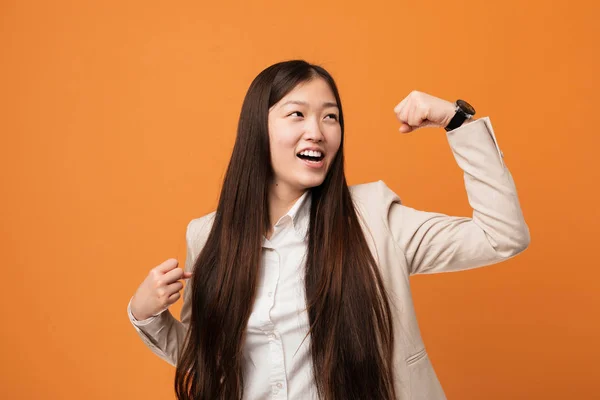 Young business chinese woman raising fist after a victory, winner concept.