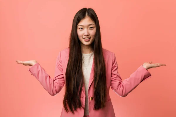 Young Business Chinese Woman Wearing Pink Suit Makes Scale Arms — 스톡 사진