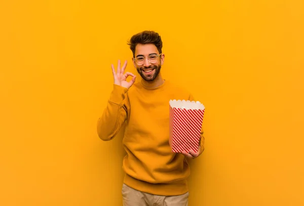 Young Man Holding Popcorns Cheerful Confident Doing Gesture — Stock Photo, Image