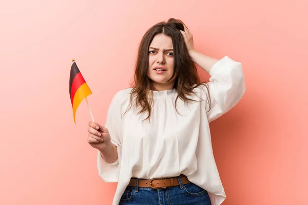若いカービープラスサイズの女性がドイツ国旗を持ってショックを受けて 彼女は重要な会議を覚えています — ストック写真
