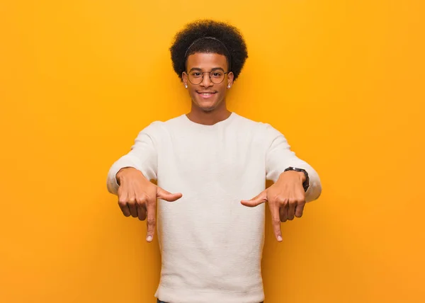 Jovem Afro Americano Sobre Uma Parede Laranja Apontando Para Fundo — Fotografia de Stock