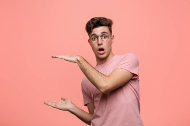 Kafkasyalı genç bir adam ellerinin arasında bir kopya alanı tutarken şok oldu ve hayrete düştü..