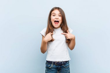 Sevimli kız geniş gülümseyerek, kendini işaret şaşırttı.