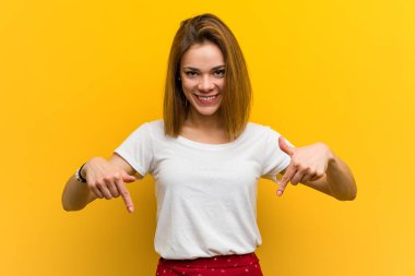 Genç, beyaz bir kadın parmaklarıyla aşağıya bakıyor, olumlu bir duygu..