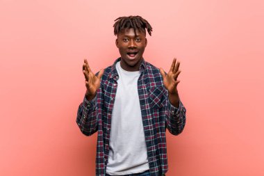 Genç Afrikalı siyah adam zaferi ya da başarıyı kutluyor.