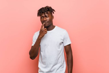 Genç Afrikalı siyahi adam şüpheli ve şüpheci bir ifadeyle yana bakıyor..